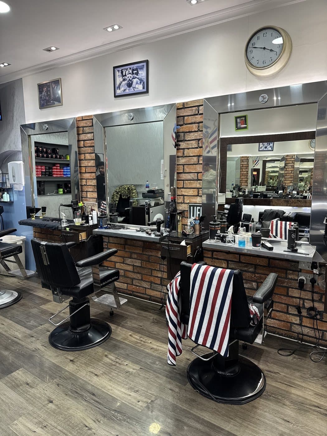 Barber chairs and mirrors along the exposed brick wall